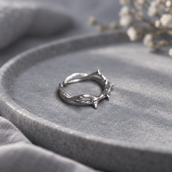 Silver crown of thorns ring styled on a grey stone tray