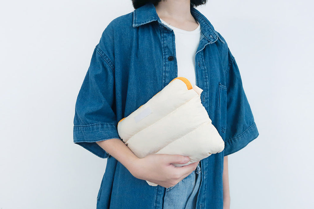 Person holding the soft Oat Pong Pong Bag against their side, highlighting its comfortable padding.