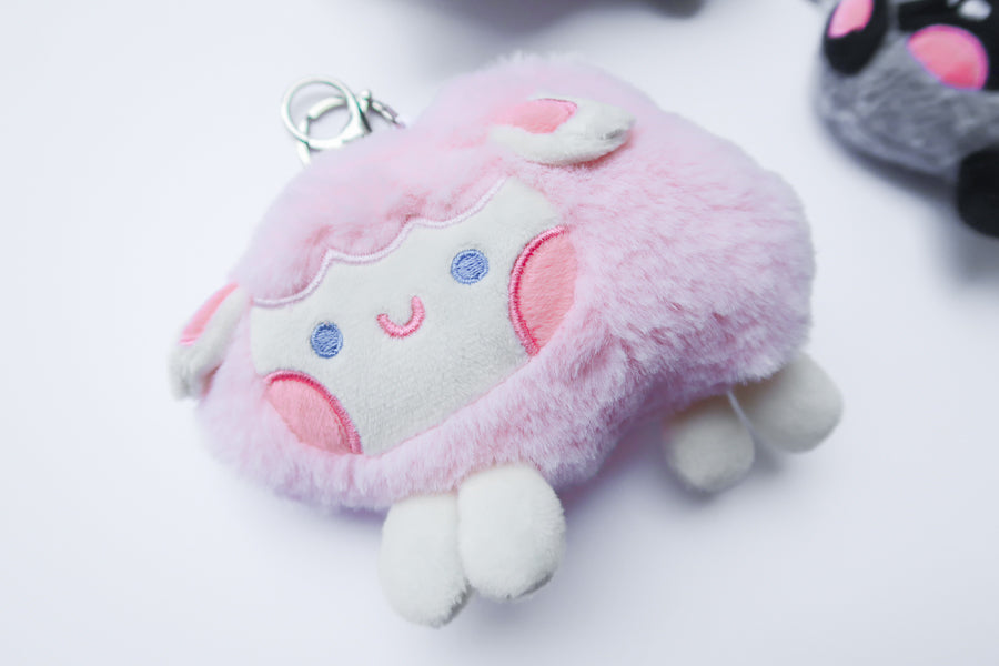 Three faith-inspired Lil Sheepies plush keychains in White Cumulus, Pink Hana, and Stormy Gray are displayed on a white background. Each soft, fluffy sheep represents a reminder of the Good Shepherd’s love, featuring a Bible verse charm, a retractable string for easy card access, and a secure keychain clip. Perfect as a Christian gift or daily faith companion.