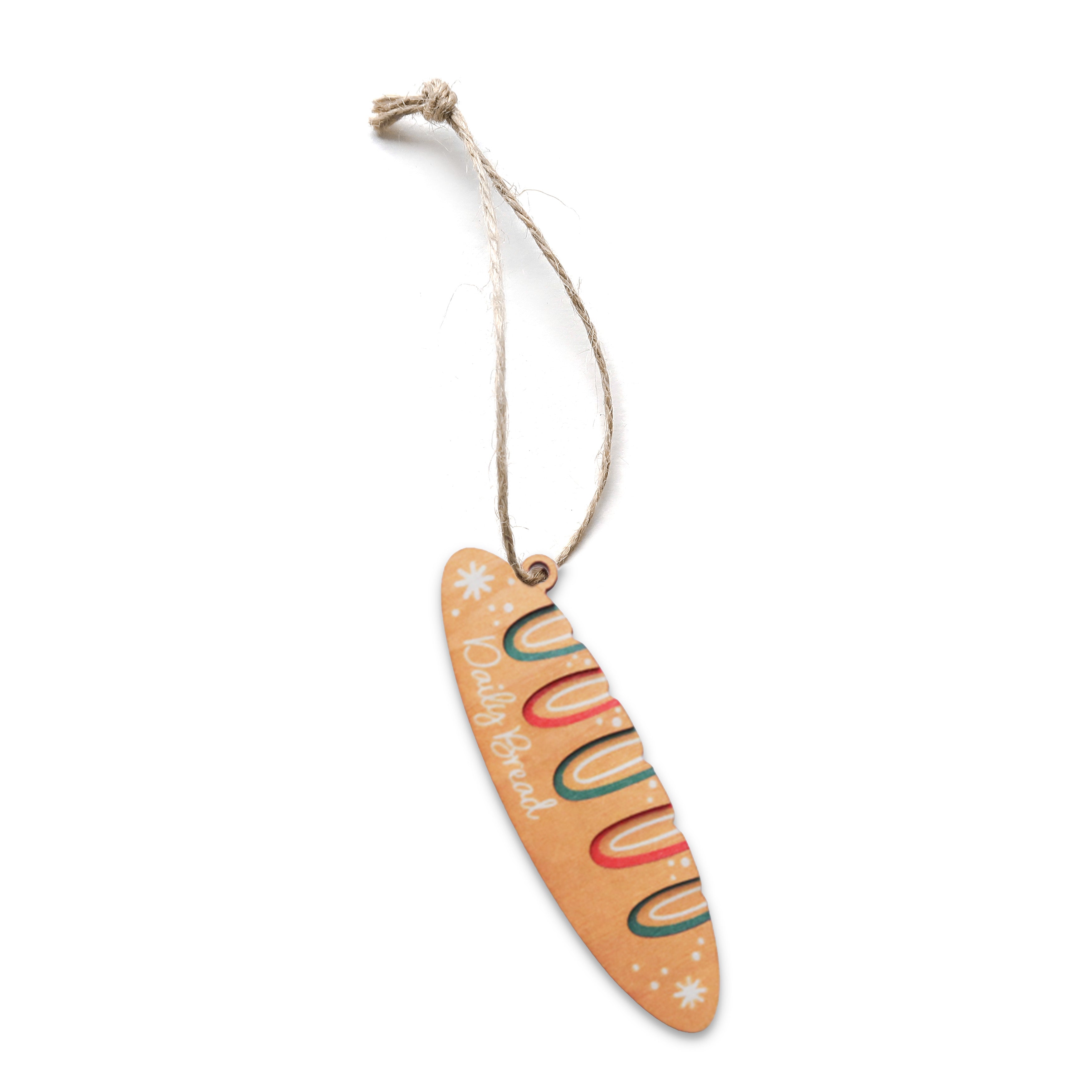 Baguette-shaped Christmas bauble with colourful details and the words ‘Daily Bread’.