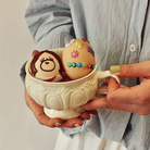 Two eggs in a cup decorated with Soft Jesus stickers, featuring playful and colorful designs.