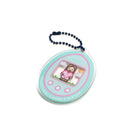 Round teal digital-pet acrylic keychain featuring pixel-art character, edge text "NURTURE YOUR FAITH," attached to a blue ball chain