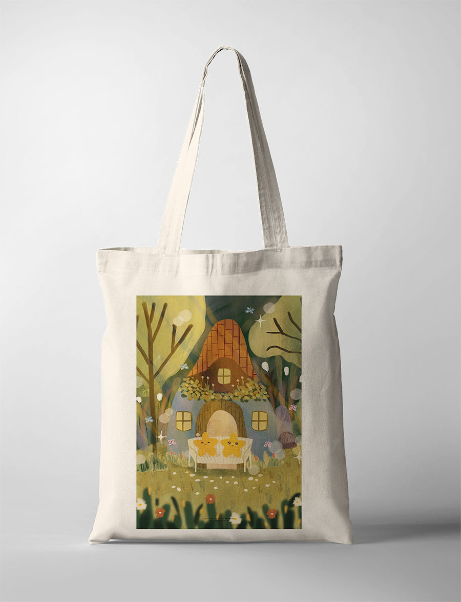Canvas tote bag with Dita illustration of a cozy cottage house surrounded by trees and flowers in a warm, whimsical setting