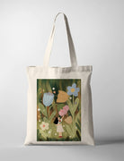Canvas tote bag featuring Dita artwork of a girl standing among large whimsical flowers in a green field, soft storybook style illustration
