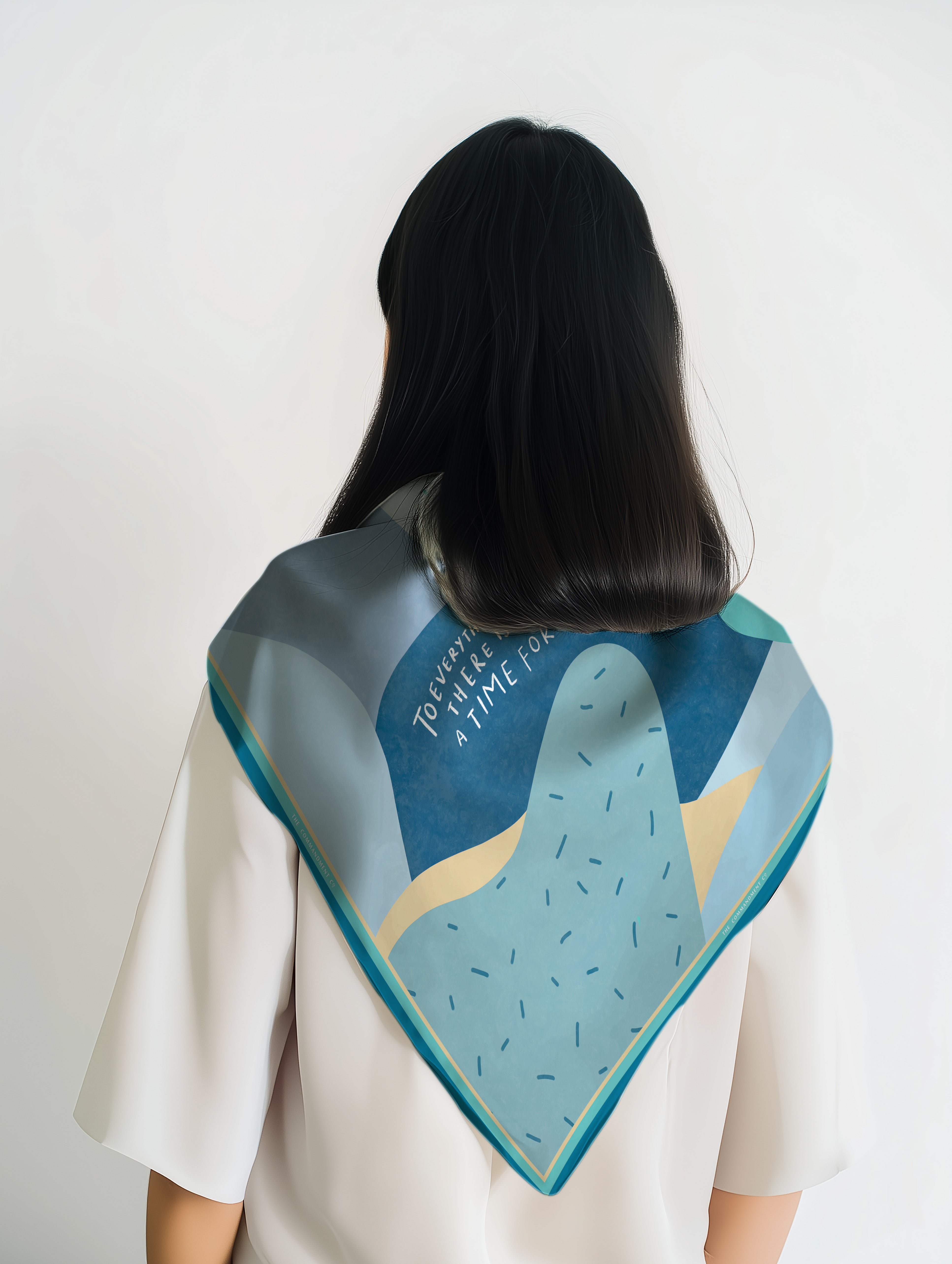Back view of a model wearing a colorful abstract scarf featuring Ecclesiastes 3:1 “To everything there is a season” in a modern Christian design by The Commandment Co.