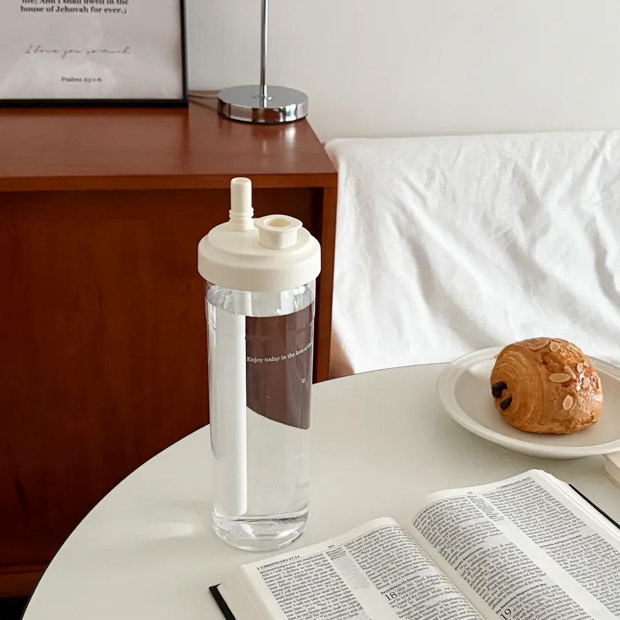 Clear water bottle featuring the message “Enjoy today in the love of God,” shown beside a Bible and breakfast pastry, perfect for daily encouragement and Christian gifting.