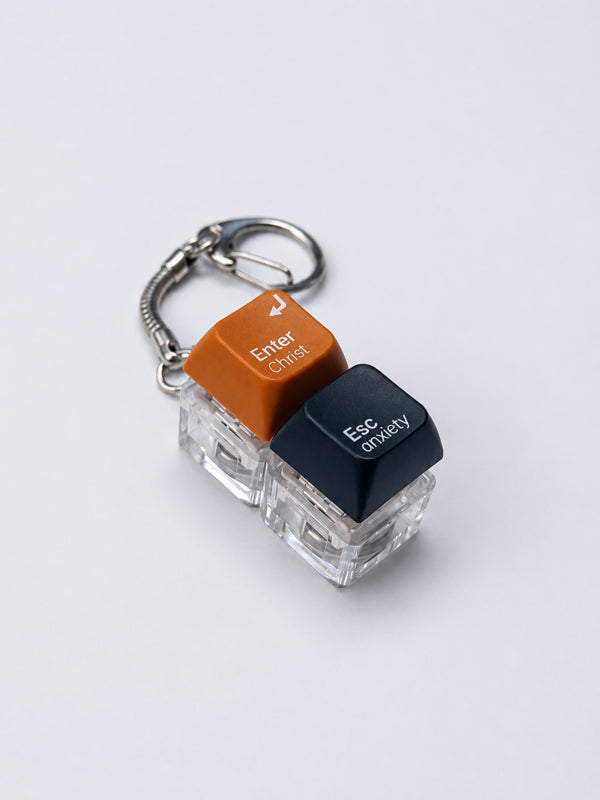 Enter Christ Esc anxiety double light-up keycap keychain in orange and black on a white background