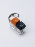 Enter Christ Esc anxiety double light-up keycap keychain in orange and black on a white background