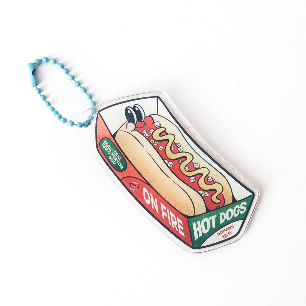 Christian keychain featuring an on-fire hot dog design with the text 'Serve the Lord enthusiastically,' inspired by Romans 12:11.