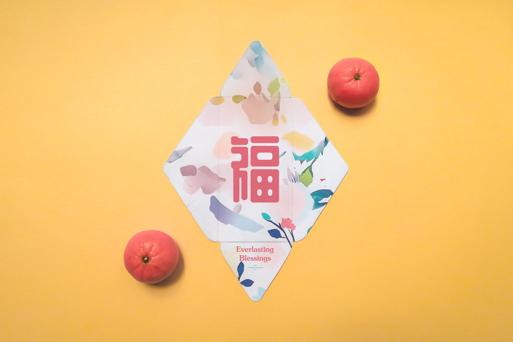 Chinese New Year red packet with 'Everlasting Blessings' theme, featuring pastel floral abstract patterns and a bold pink Chinese character, placed alongside tangerines on an orange background.