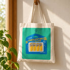 Everlasting Love Battery AAA tote bag hanging on a wooden wall hook in warm natural light.