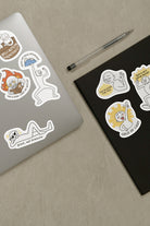 Laptop and notebook adorned with Everyday Believer stickers featuring Christian messages like "Grace, Not Pressure" and "Child of Light," from The Commandment Co, Singapore.