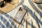 Phone case decorated with Everyday Believer stickers featuring Christian messages like "Run & Not Grow Weary" and "Trust the Wait," alongside a sun hat and sunglasses, from The Commandment Co, Singapore.