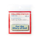 Beige Velcro tag with blue text 'For the Glory of God,' an embroidered inspirational patch for faith-based apparel and accessories