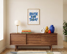 Faith for Today Christian poster displayed above a wooden sideboard in a warm modern interior