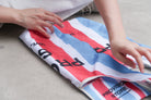 Hands folding a Provision 
Store Bible verse 
shopping bag with red, 
blue, and white stripes, 
demonstrating its reusable 
and practical design for 
Christian gifts. 