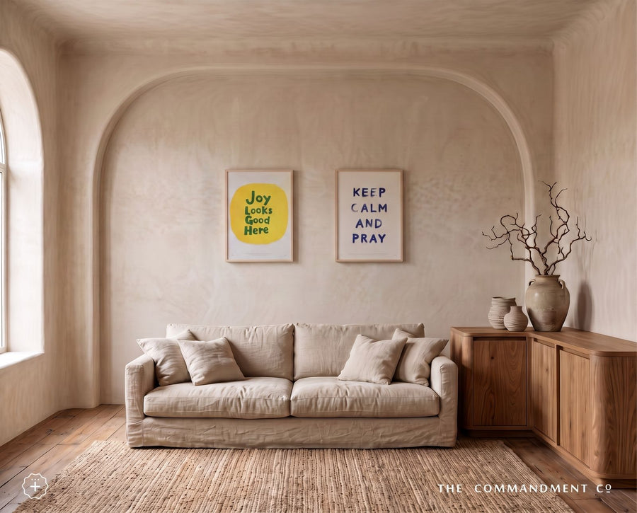 Joy Looks Good Here poster styled beside a Keep Calm and Pray print in a neutral living room
