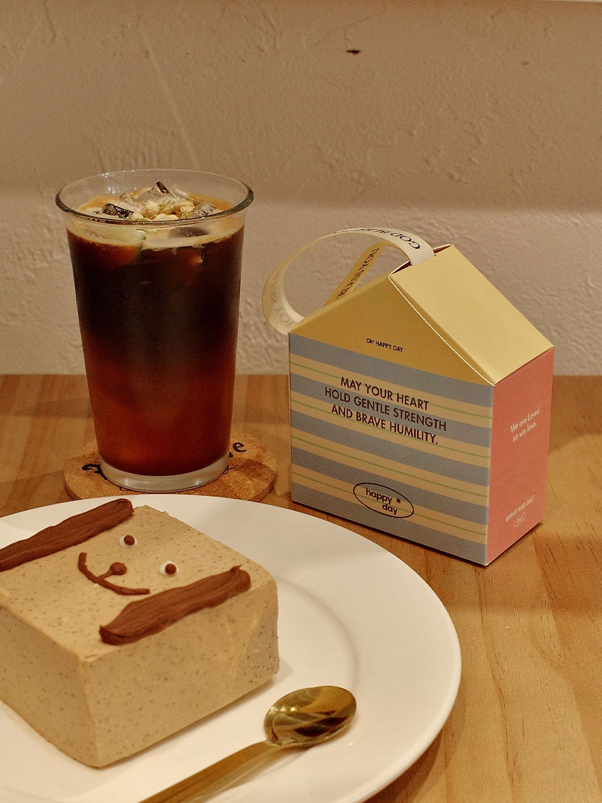 Cute house gift box placed next to dessert and drink showing creative small gift packaging idea