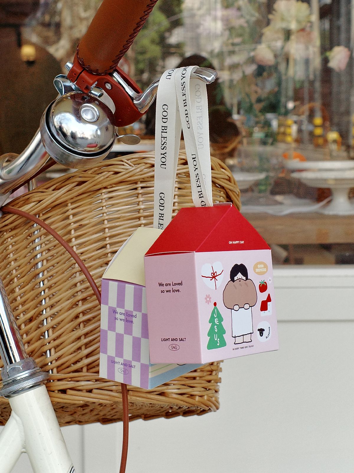 Kawaii house gift box hanging on bicycle basket showing unique portable gift packaging design