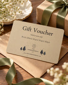 The Commandment Co physical gift voucher styled with a kraft envelope, ribbon and gift box.