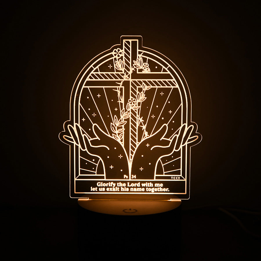 Christian LED lamp with a cross, two hands raised in worship, and the Bible verse from Psalm 34: 'Glorify the Lord with me, let us exalt his name together.'