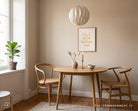 God Goes Before Me Christian poster styled above a wooden dining table in a warm neutral room