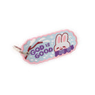Smiling white bunny on a blue keychain with the phrase 'GOD IS GOOD' in embroidery.