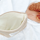 God is like warm sunshine beige corduroy zipper clutch with an inspirational message patch, placed on a textured white fabric, radiating simple happiness and encouragement.