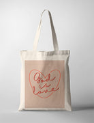 Christian canvas tote bag with “God is Love” heart typography design, created in collaboration with Moojigae Drawing, minimalist faith-based tote bag