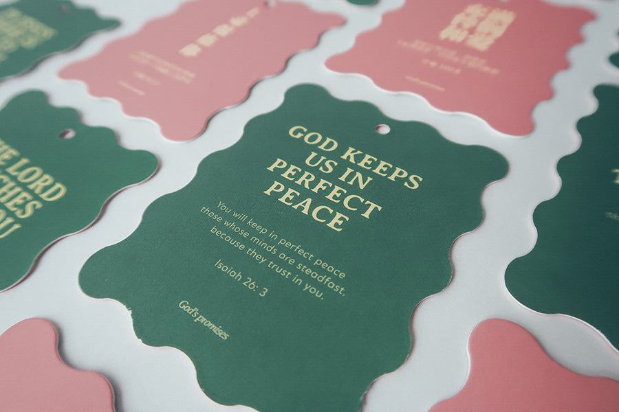 Christian Christmas tree hanging ornaments or bookmarks featuring Bible verses such as 'God Keeps Us in Perfect Peace' with green and pink scalloped designs.