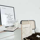 God Your love is my dependence canvas tote bag on a rattan chair, beside a cozy desk with an inspirational prayer print, a faith-themed glass, and a soft brown scarf, creating a peaceful and uplifting atmosphere.