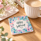 Grace Is Sufficient 2 Corinthians 12:9 floral coaster beside a coffee cup on a wooden table