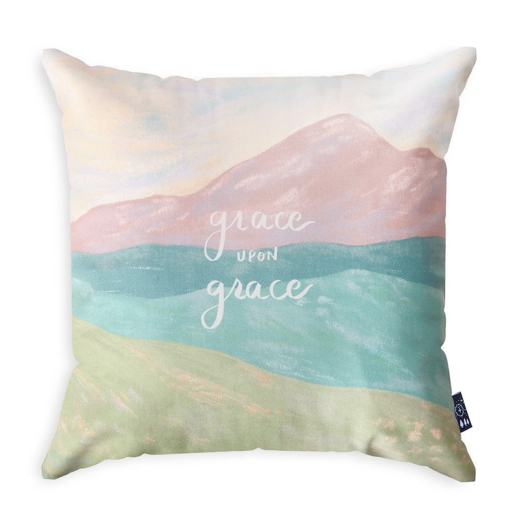 Decorative throw pillow featuring the text 'Grace Upon Grace' with a pastel mountain and landscape design, perfect for Christian faith-based home decor.