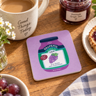 Grapeful Jam Christian coaster from the Love Supermarket collection styled beside coffee, grape jam and grapes on a wooden table.