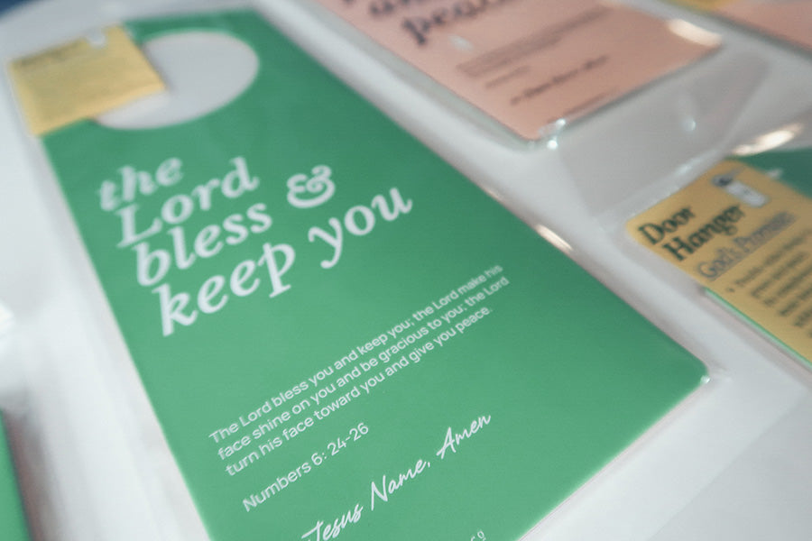 Close-up view of a green Christian door hanger featuring the Bible verse 'The Lord bless and keep you' from Numbers 6:24-26, highlighting faith and blessings.