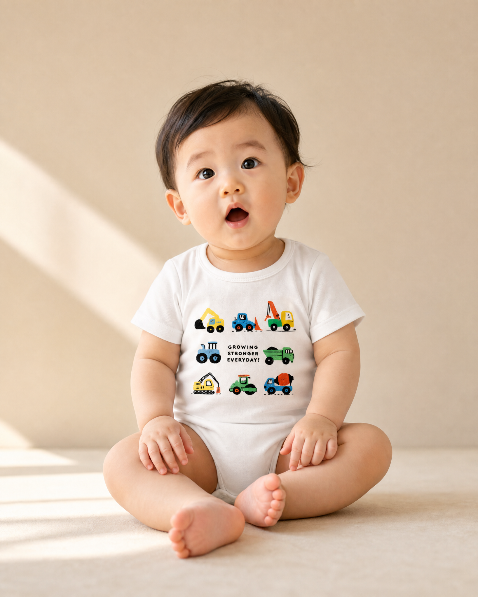 Baby wearing Growing Stronger Everyday construction vehicle romper