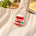 Hallelujah chocolate spread acrylic pin on a cream canvas tote bag