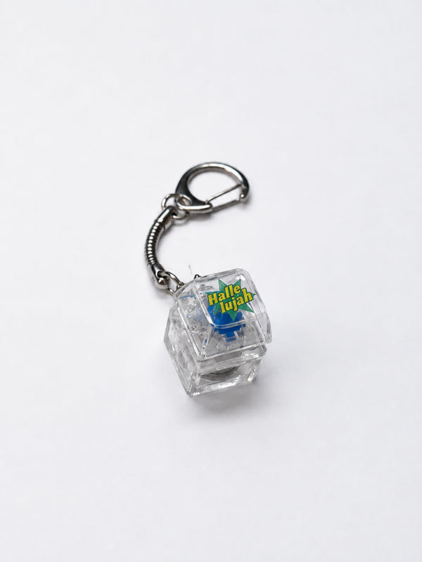 Hallelujah light-up keycap keychain with a transparent keycap and silver clasp on a white background