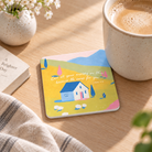 He Cares for You 1 Peter 5:7 Christian coaster beside a coffee cup on a warm sunlit wooden table.