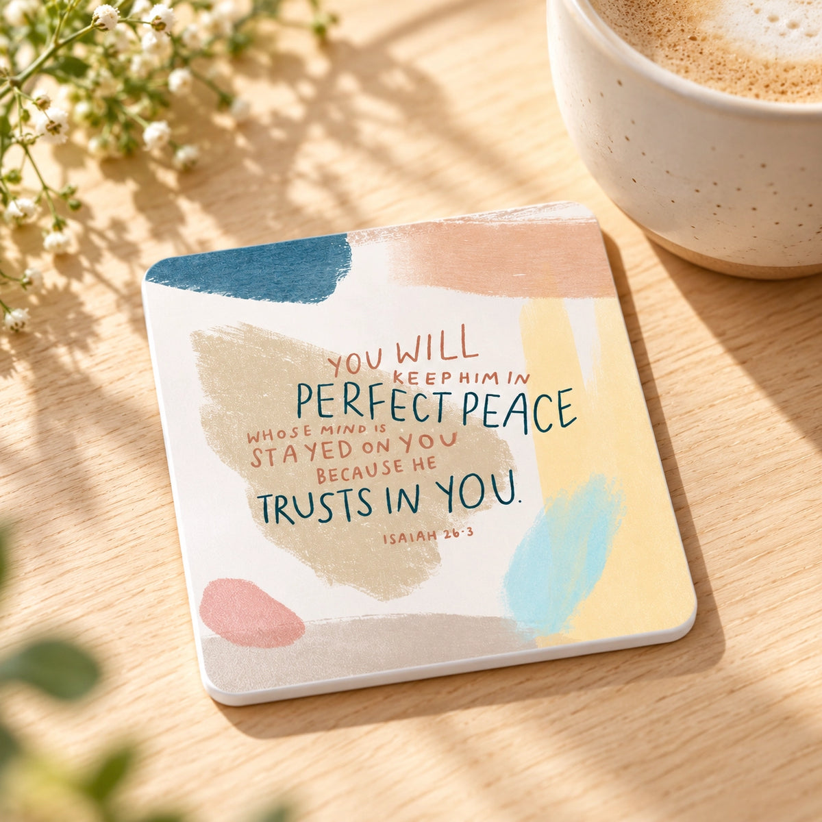 He Trusts In You Christian coaster with Isaiah 26:3 styled beside a coffee cup