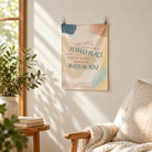 He Trusts in You small wall tapestry displaying Isaiah 26:3 in a sunlit living room above a cushioned chair