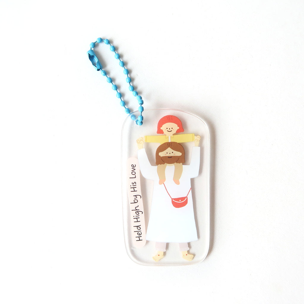 Christian keychain featuring an illustration of Jesus carrying a smiling child on His shoulders with the text 'Held High by His Love' and a blue chain.