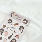"Hey! I Love You" sticker sheet featuring cute illustrations of Jesus, bread, pretzels, and uplifting icons, perfect for sharing encouragement and simple happiness.