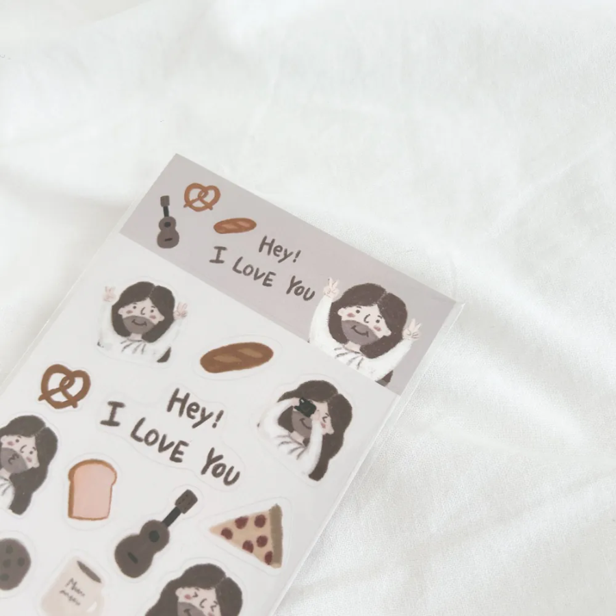 "Hey! I Love You" sticker sheet featuring cute illustrations of Jesus, bread, pretzels, and uplifting icons, perfect for sharing encouragement and simple happiness.