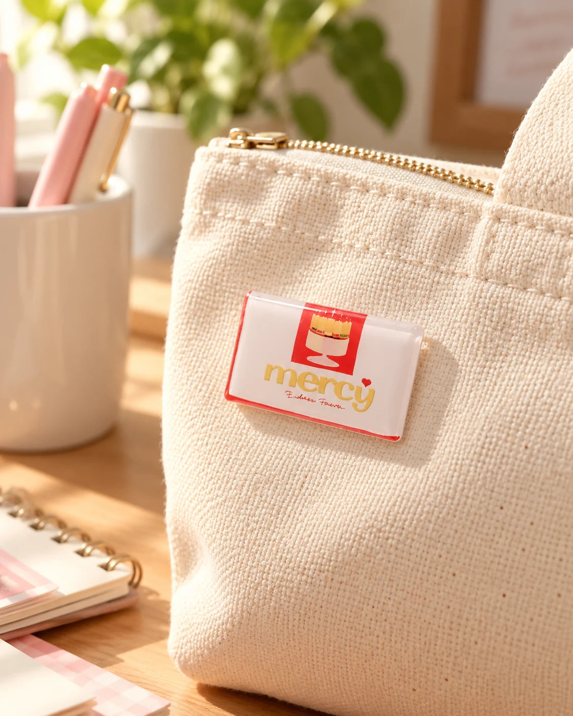 His Mercy Endures Forever LOVE SUPERMARKET pin with red and cream packaging design on a canvas bag.