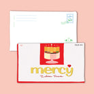 Christian postcard designed like a chocolate bar wrapper with the words “His mercy endures forever” inspired by Psalm 118:2, featuring a cake illustration in red and gold tones.