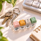 HOPE press-on light-up keycap keychain attached to a set of keys on a bright desk.
