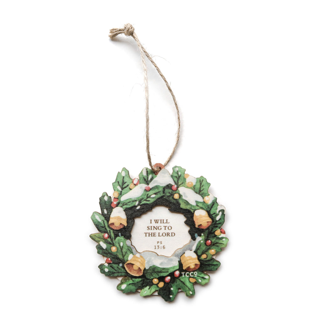 Faith-inspired Christmas ornament featuring a decorative wreath with snow and bell designs, showcasing the verse 'I will sing to the Lord' from Psalm 13:6, perfect for holiday decorations or spiritual gifts