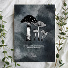 A black and white greeting card featuring an illustration of mushrooms with the quote 'In the midst of darkness, growth persists.' The design is surrounded by green foliage, offering a message of resilience and hope.