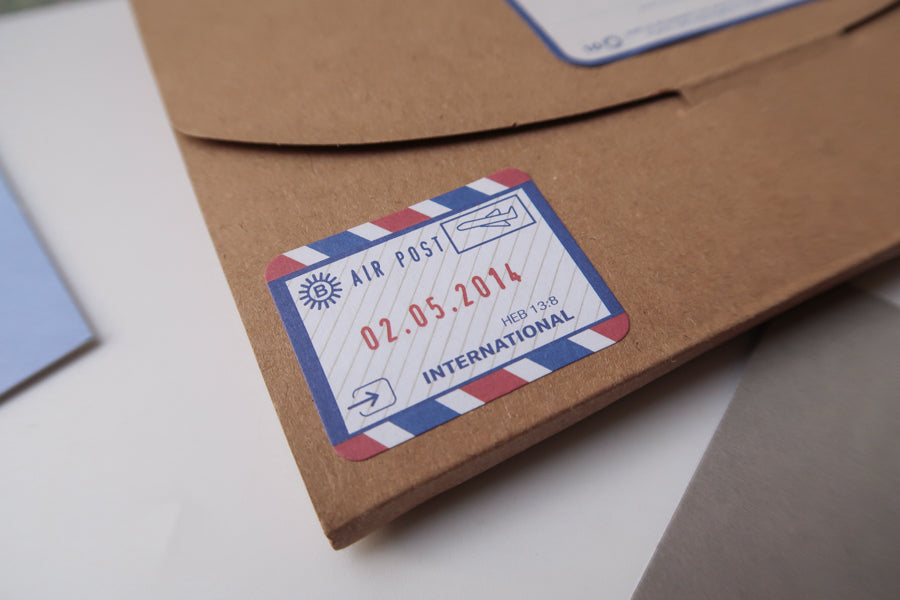 A close-up of a brown envelope featuring a vintage-style air post label dated 02.05.2014, marked 'International,' adding a nostalgic touch to the package.